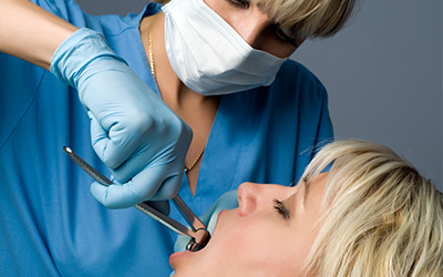 A dentist extracting a tooth from a patient