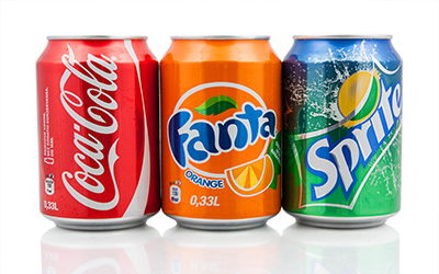 An image of soda cans that include coke, sprite and fanta