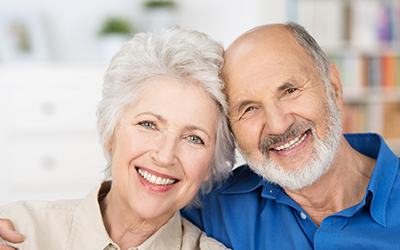 An older man and woman smiling together