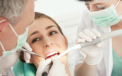 A dentist working on a female patients teeth